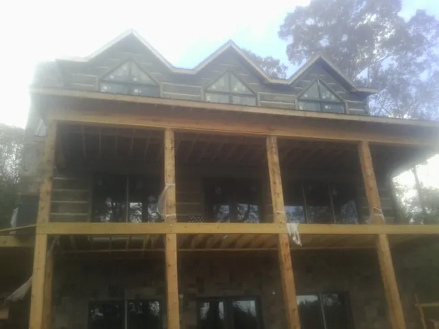 Dormers and porch framing on a large log home under construction — Roof Coating work by our crew in Mount Juliet