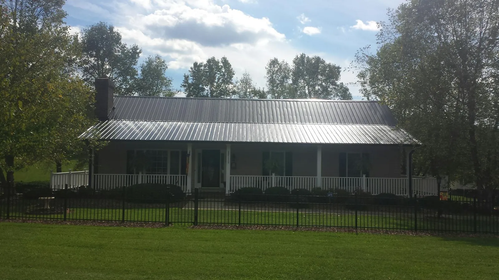 Gray metal roof on a brick ranch with a full width front porch — Gutter Guard Installation work by our crew in Mount Juliet