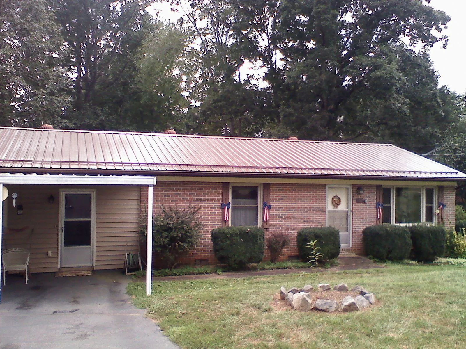 Bronze metal roof and carport on a brick ranch home — Roof Repair work by our crew in Mount Juliet